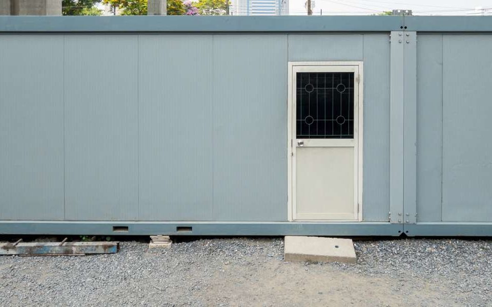 A container repurposed into an office space for temporary rentals. There's a front door on the outside.