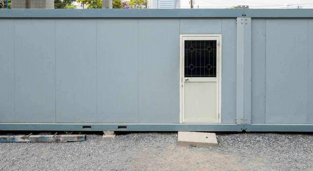 A container repurposed into an office space for temporary rentals. There's a front door on the outside.