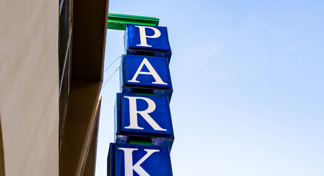 The word "park" spelled vertically in four bright-blue signage cubes attached to the side of a building.